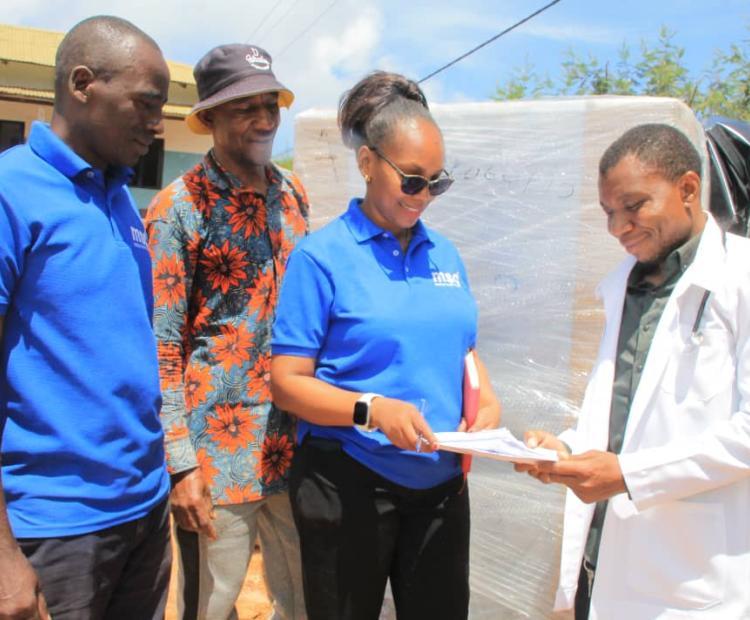 Tanga Zone Medical Depot (MSD) Customer Service Officer, Mary Isango, providing various documents to the Medical Officer of the Mtae Village Health Center located in Lushoto, Tanga Region,